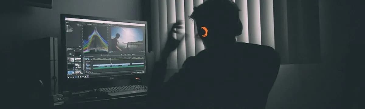 Video editor working at a computer in a dark studio